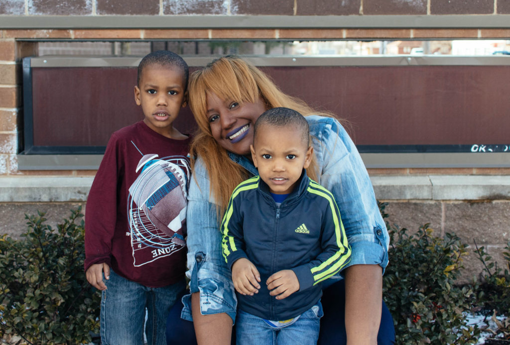Smiling Black mom with two young boys sons