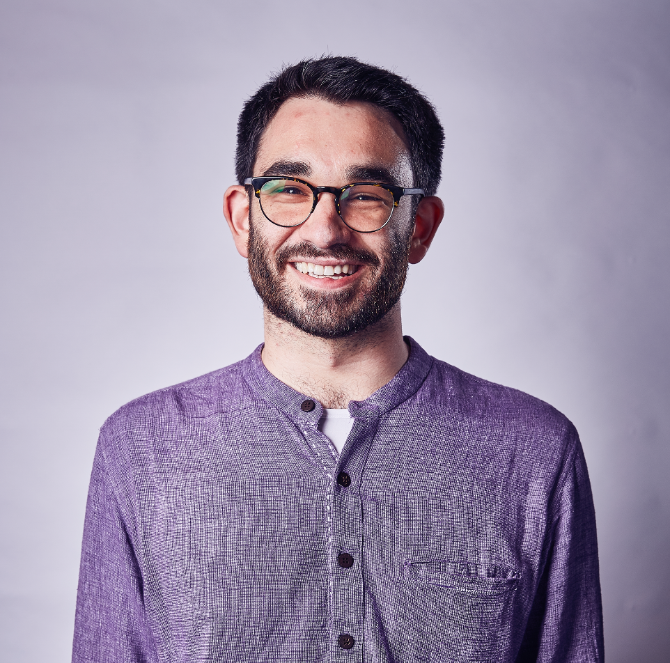 Smiling young white man with beard and glasses