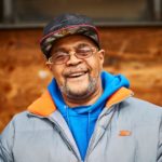smiling older black man in glasses and baseball cap