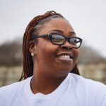 smiling black woman with braids and glasses