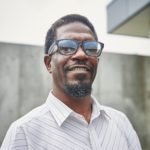 Smiling Black man with goatee and glasses