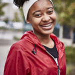 Grinning young Black woman with braces and headband