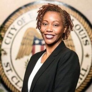 Smiling black woman with braids wearing a suit