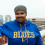 Black woman wearing STL Blues jersey smiling