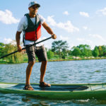 man stand up paddle boarding