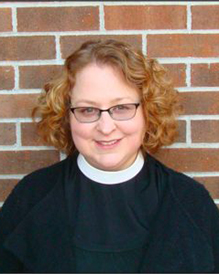 Smiling white woman priest with curly hair