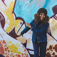 Happy Black girl in front of mural